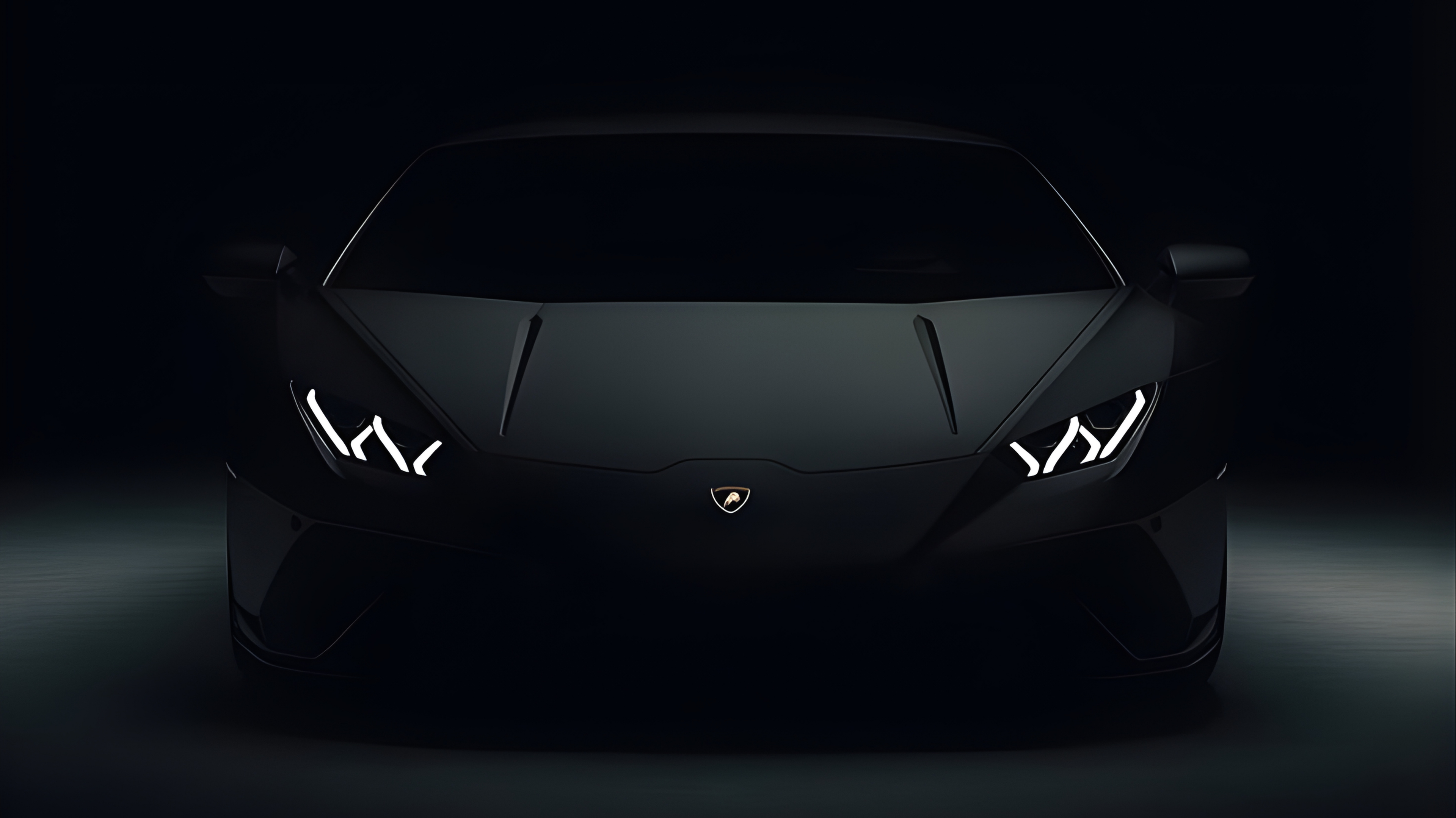 Black Lamborghini sports car with illuminated headlights on a dark background